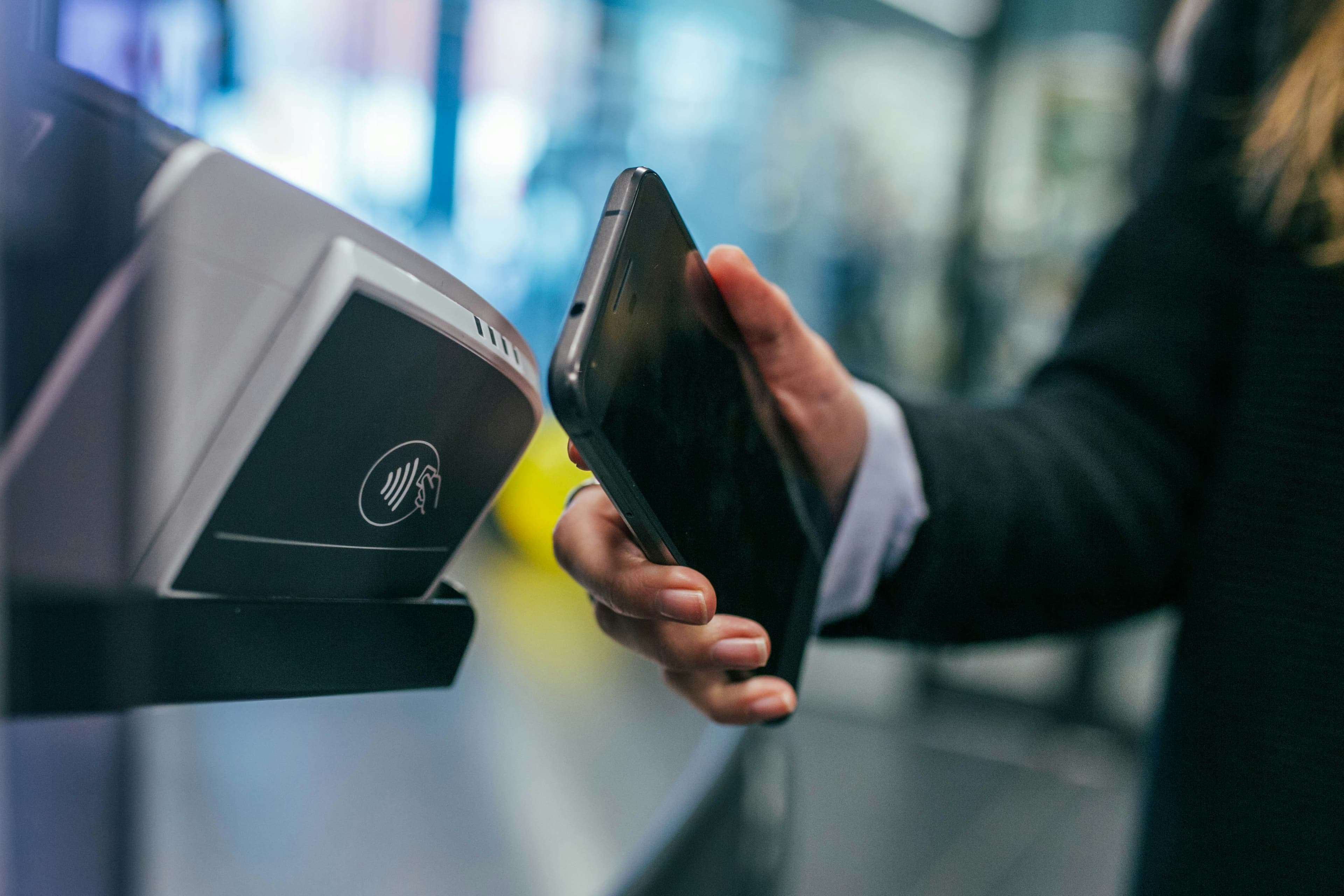 A customer tapping a phone to pay at a checkout terminal